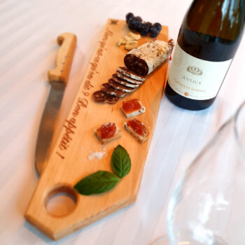 planche apéritif en bois massif avec saucisson, raisin, basilic, verre de rosé