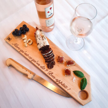 planche apéritif en bois massif avec saucisson, raisins, basilic, verre de rosé