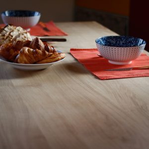 Viennoiseries et bols de petit déjeuner sur table en chêne massif