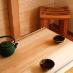 Une théière et deux bols à thé sur une table ne bois massif